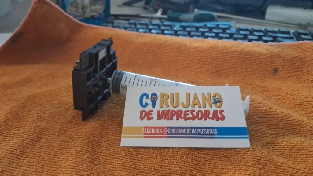 Jeringa conectada a una entrada de tinta de un cabezal Epson obstruido